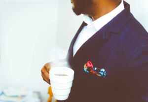 Man in a suit holding a cup of coffee